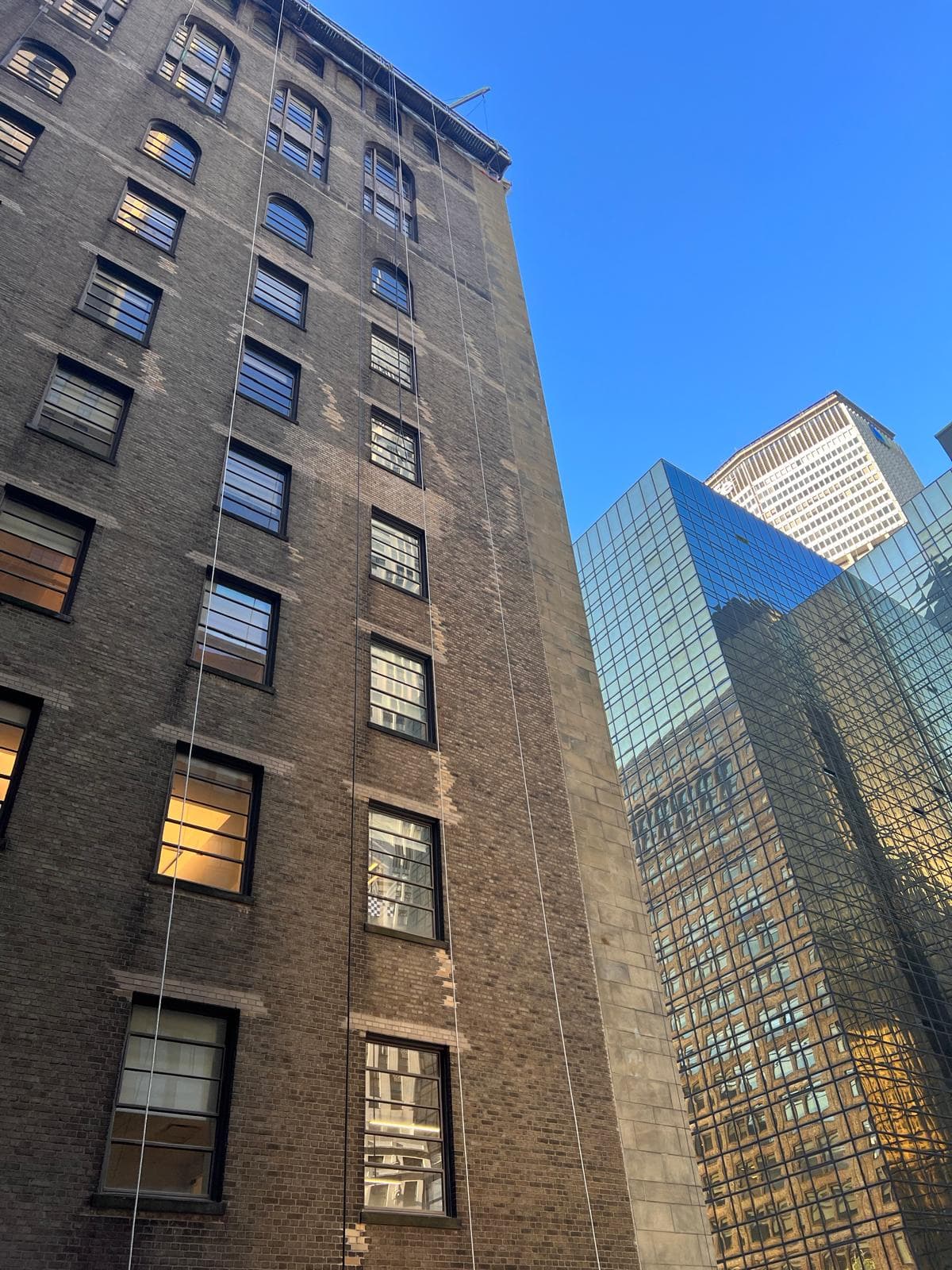 Historic brick facade beside a modern glass tower in New York City